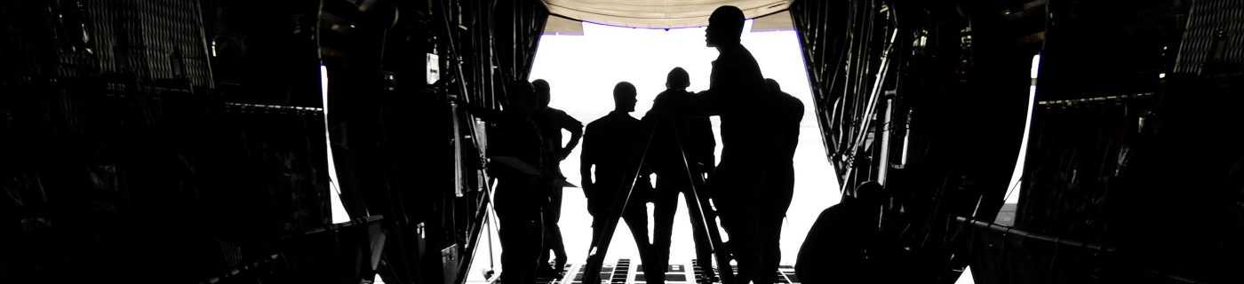 military shadowed people in plane hangar