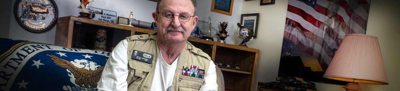 Veteran in front of military paraphernalia