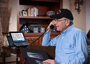 Man talking on 2400i captioned phone